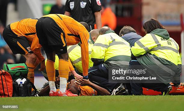 Anthony Gardner of Hull is given treatment on the pitch before being stretcherd off during the Barclays Premier League match between West Ham United...