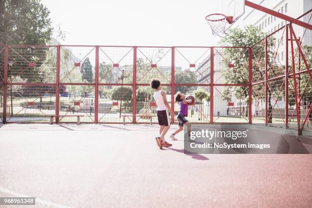 cute mixed race siblings playing basketball outdoors on basketball court - fraternity brother stock pictures, royalty-free photos & images