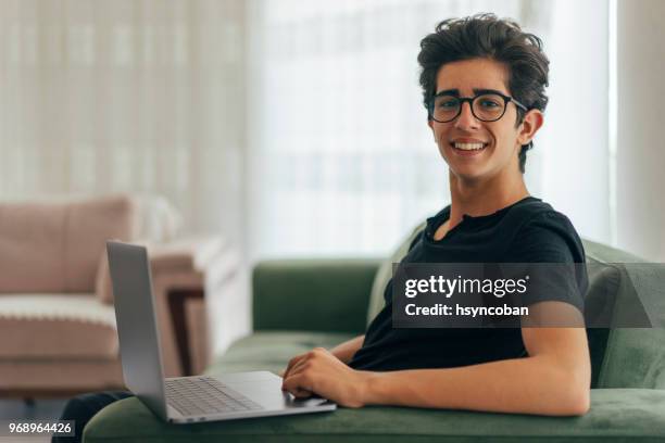 tiener met behulp van laptop thuis - fair haired boy stockfoto's en -beelden