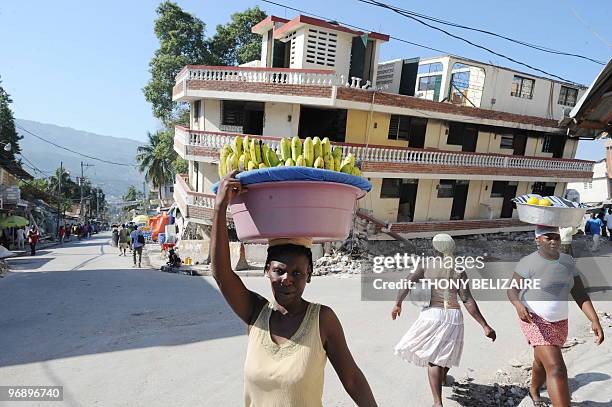 Haitian woman passes on February 20, 2010 a destroyed building in Port-au-Prince. Reflecting the massive needs in what was already the poorest...