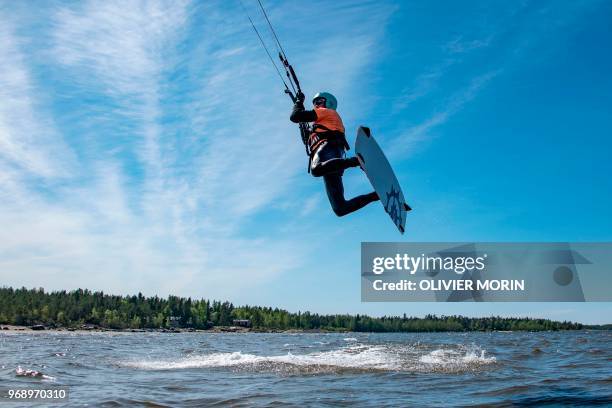 Former Finnish Olympic gymnastics athlete in Rome and Tokyo , Kauko Heikkinen jumps as he rides a kitesurf in Storsand, northern Vaasa, western...
