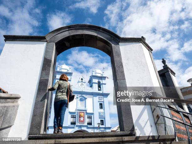 woman doing tourism and contemplating the misericordia church city of angra do heroismo, a unesco world heritage site, on terceira island in the azores, portugal. - azores people stock pictures, royalty-free photos & images
