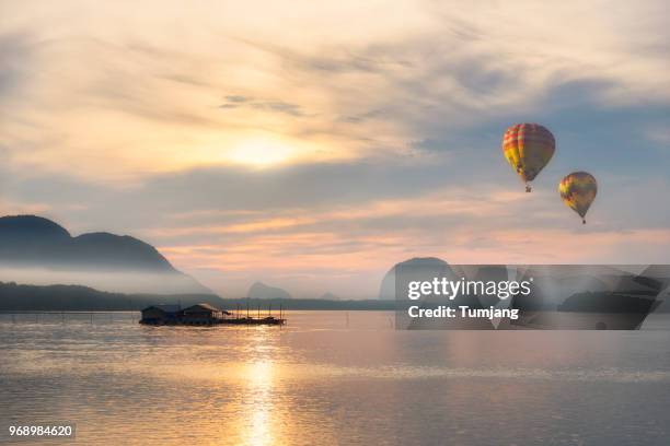 hot air balloons on the beach background is hill moutain fog and fisherman village - hot air ballon foto e immagini stock