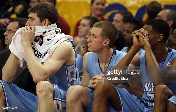 Tyler Zeller,David Wear and John Henson of the North Carolina Tar Heels watch from the bench as the Boston College Eagles win the game on February...
