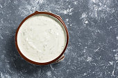 Greek sauce of tzatziki on a gray background. The view from above, flat lay.
