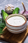 Greek traditional sauce tzatziki on a gray background, cucumbers, garlic, dill.