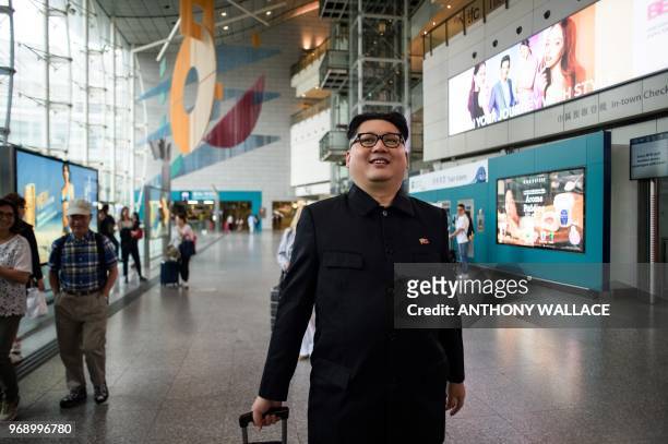 Kim Jong Un impersonator , who goes by the name Howard X, walks with luggage that he borrowed from a passenger in the Airport Express train station...