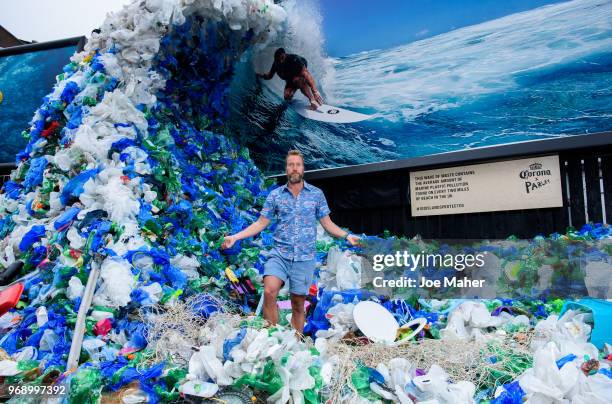 Ben Fogle stands in front giant wave of plastic waste collected from Holywell beach by the Marine Conservation Society, is seen on Old Street on June...