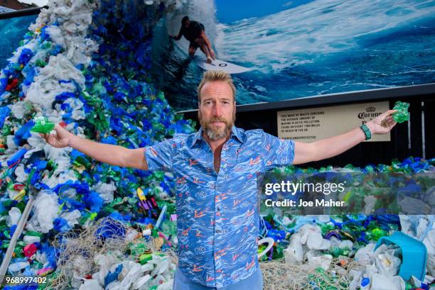 Ben Fogle stands in front giant wave of plastic waste collected from Holywell beach by the Marine Conservation Society, is seen on Old Street on June...