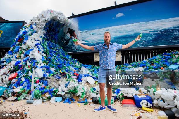 Ben Fogle stands in front giant wave of plastic waste collected from Holywell beach by the Marine Conservation Society, is seen on Old Street on June...