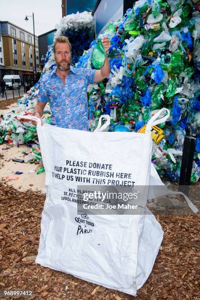 Ben Fogle stands in front giant wave of plastic waste collected from Holywell beach by the Marine Conservation Society, is seen on Old Street on June...