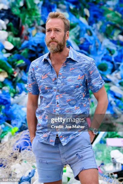 Ben Fogle stands in front giant wave of plastic waste collected from Holywell beach by the Marine Conservation Society, is seen on Old Street on June...