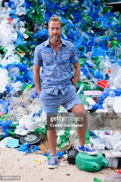 Ben Fogle stands in front giant wave of plastic waste collected from Holywell beach by the Marine Conservation Society, is seen on Old Street on June...