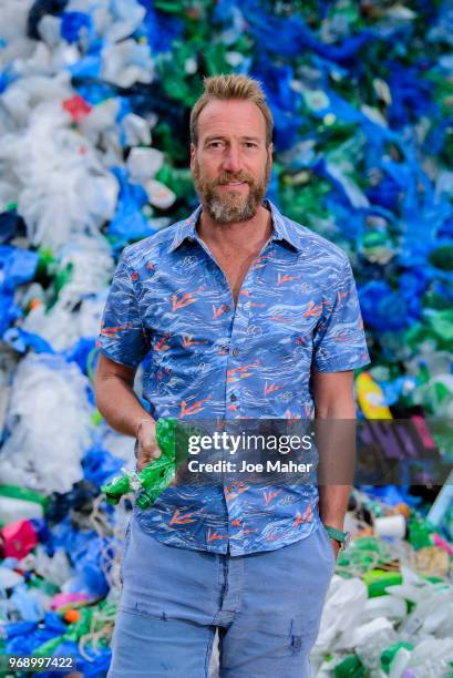 Ben Fogle stands in front giant wave of plastic waste collected from Holywell beach by the Marine Conservation Society, is seen on Old Street on June...
