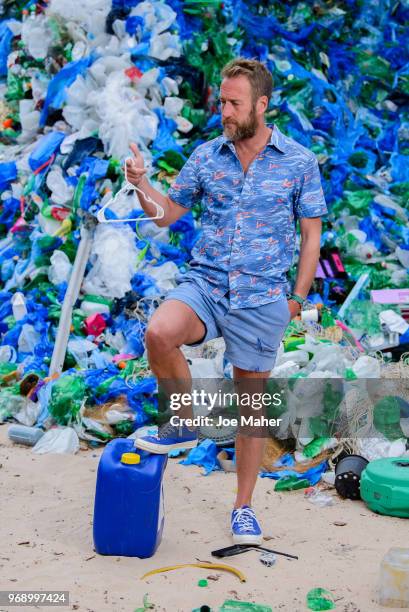 Ben Fogle stands in front giant wave of plastic waste collected from Holywell beach by the Marine Conservation Society, is seen on Old Street on June...