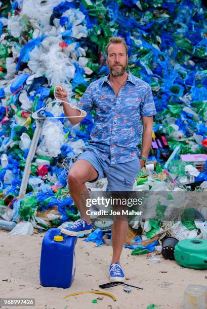 Ben Fogle stands in front giant wave of plastic waste collected from Holywell beach by the Marine Conservation Society, is seen on Old Street on June...