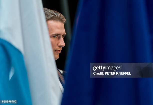 Austria's Chancellor Sebastian Kurz is seen between the flags of Bavaria and Europe as he gives a statement during a meeting of the European...