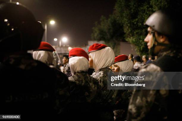 Jordanian police women stand guard beside anti riot police during a demonstration against a draft income tax law near the prime minister's office in...