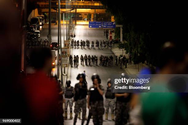 Jordanian anti riot police stand in lines to protect the prime minister's office during a demonstration against a draft income tax law in Amman,...