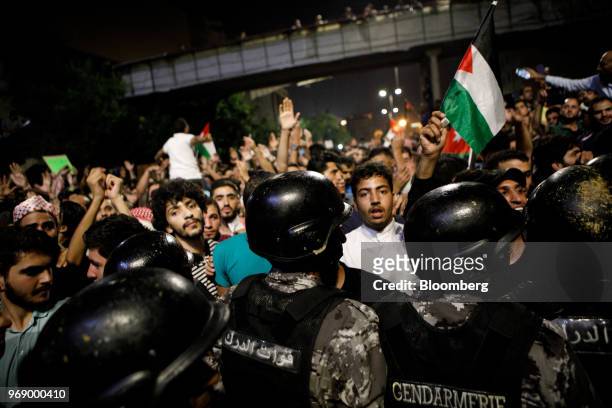 Protesters confront anti riot police during a demonstration against a draft income tax law near the prime minister's office in Amman, Jordan, on...