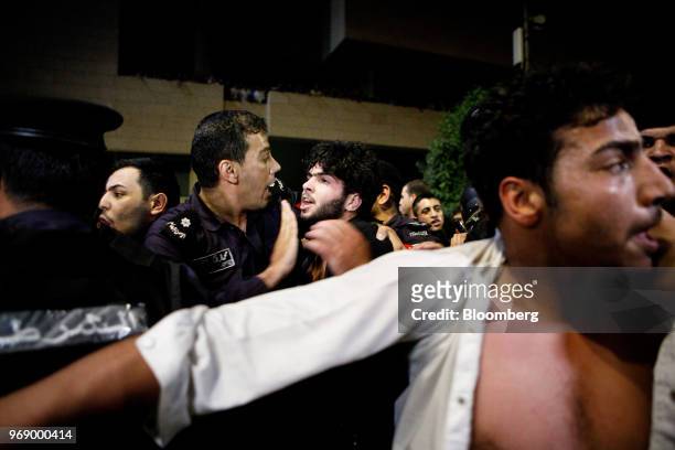 Jordanian anti-riot police push back protesters during a demonstration against a draft income tax law near the prime minister's office in Amman,...
