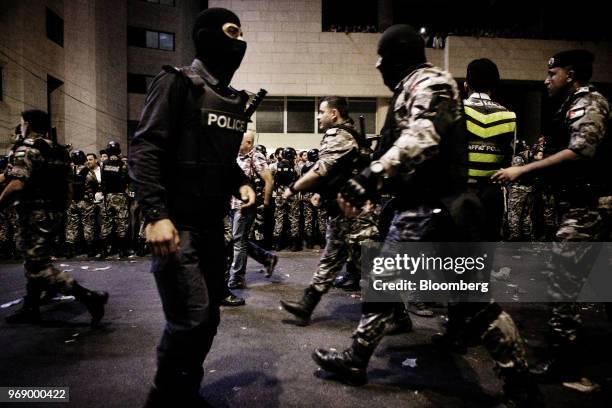 Jordanian anti-riot police guard the prime minister's office during a demonstration against a draft income tax law in Amman, Jordan, on Wednesday,...