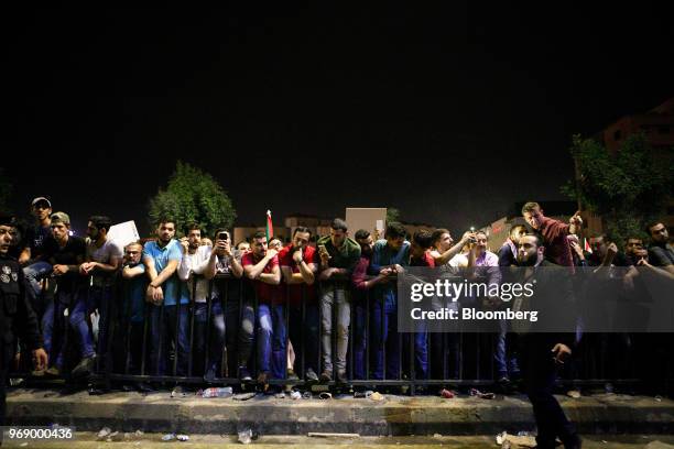 Protesters look on from the other side of the street to anti riot police during a demonstration against a draft income tax law near the prime...