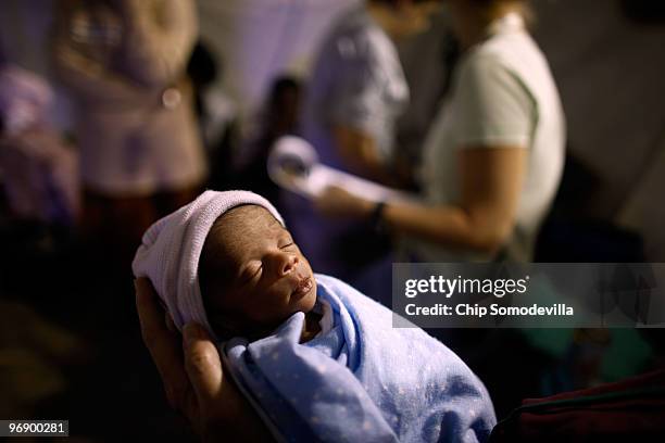 Premature baby, named Fred Jr., is carried to a scale to be weighed at the Project MediShare field hospital on the grounds of the Toussaint...