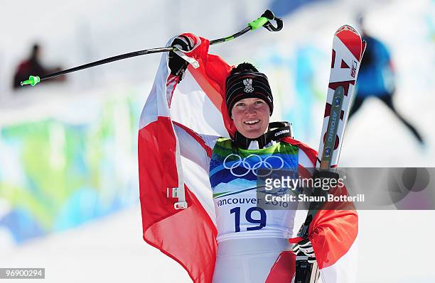 Andrea Fischbacher of Austria celebrates with the Austrian flag after winning the gold medal in the women's alpine skiing Super-G on day nine of the...