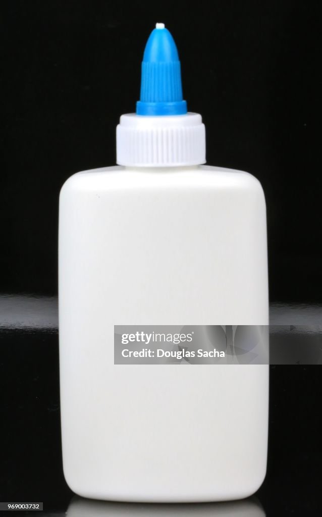 Bottle of children's art and craft glue bottle on a black background