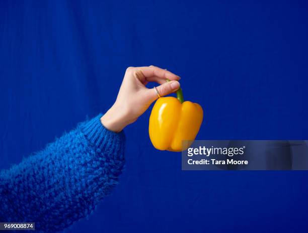 hand holding yellow bell pepper - hand with bell stockfoto's en -beelden