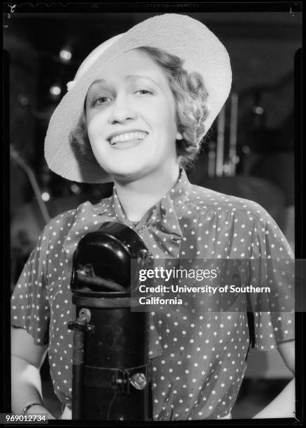 Ruth Etting and Gus Arnheim looking at paper, with microphone, and with sheet music, Southern California, 1934.