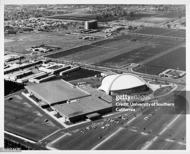 Aerial view of the Anaheim Convention Center, Disneyland parking lots, and a section of the Disneyland monorail, Anaheim, California, early to mid...