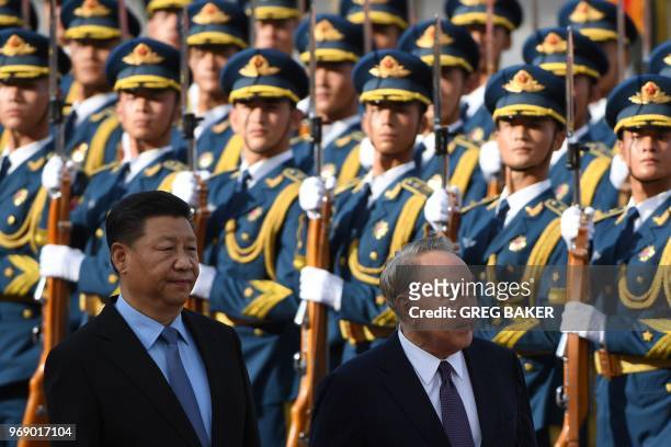 Kazakhstan's President Nursultan Nazarbayev reviews a military honour guard with Chinese President Xi Jinping during a welcome ceremony outside the...