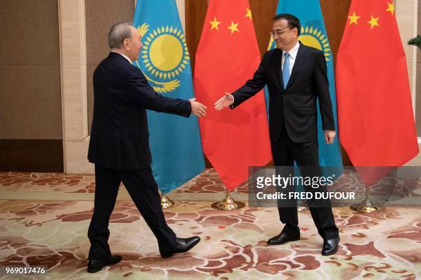 Kazakhstan's President Nursultan Nazarbayev shakes hands with China's Premier Li Keqiang during a meeting at the Diaoyutai State Guesthouse in...