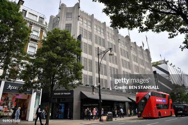 Pedestrians walk past the entrance to House of Fraser department store on Oxford Street in London on June 7, 2018. - Britain's department store chain...