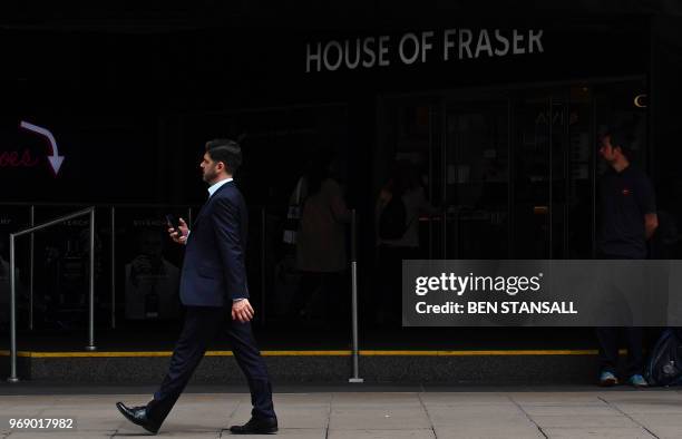 Pedestrians walk past the entrance to House of Fraser department store on Oxford Street in London on June 7, 2018. - Britain's department store chain...