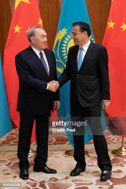 Kazakhstan's President Nursultan Nazarbayev shakes hand with China's Premier Li Keqiang during a meeting at the Diaoyutai State Guesthouse,on June 7...
