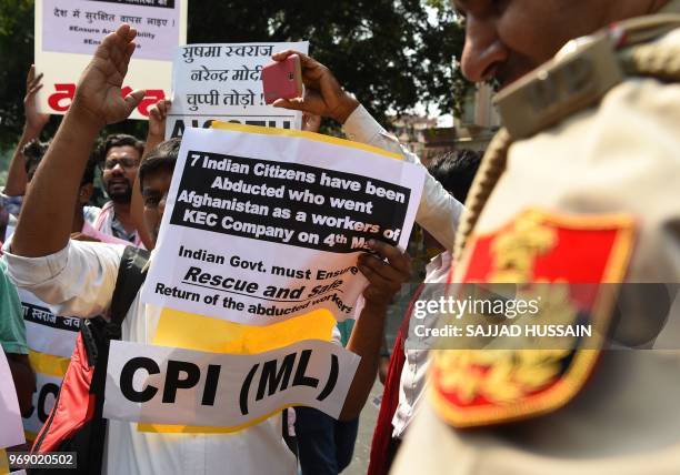 Indian demonstrators and relatives hold placards during a protest against the kidnaping of seven Indian citizens working in Afghanistan, in New Delhi...