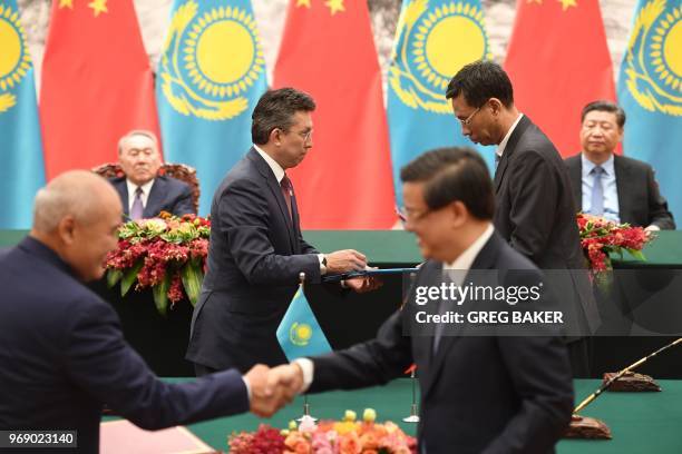 Kazakhstan's President Nursultan Nazarbayev and Chinese President Xi Jinping preside over a signing ceremony in the Great Hall of the People in...