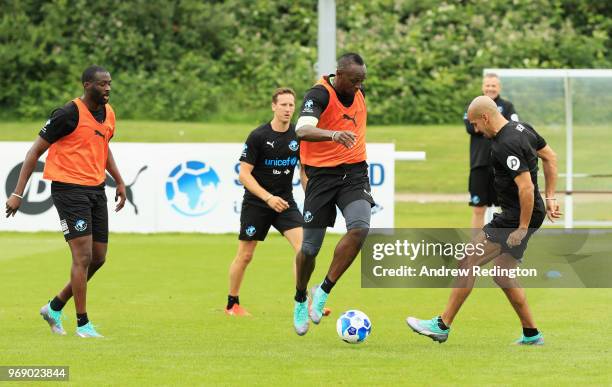 Usain Bolt of the Rest of the World takes part in training with team mates Yaya Toure, Brendan Cole and Juan Sebastian Veron during a Soccer Aid for...