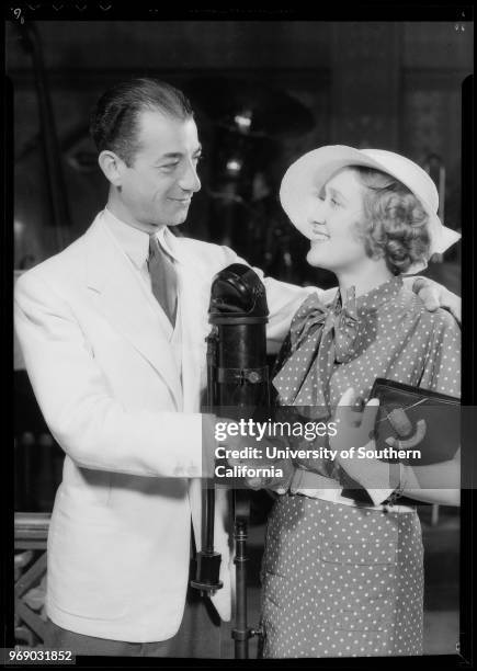 Ruth Etting and Gus Arnheim looking at paper, with microphone, and with sheet music, Southern California, 1934.