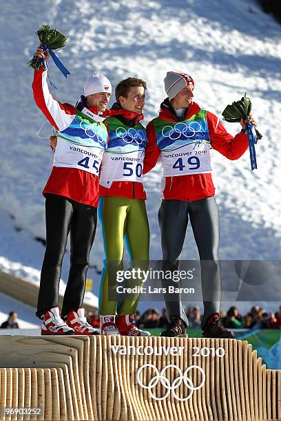 Simon Ammann of Switzerland celebrates his Gold medal, Adam Malysz of Poland Silver and Gregor Schlierenzauer of Austria after the final jump the...