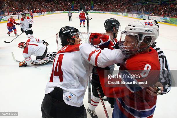 Mads Hansen of Norway and Roman Wick of Switzerland throws a punch during the ice hockey men's preliminary game between Norway and Switzerland on day...