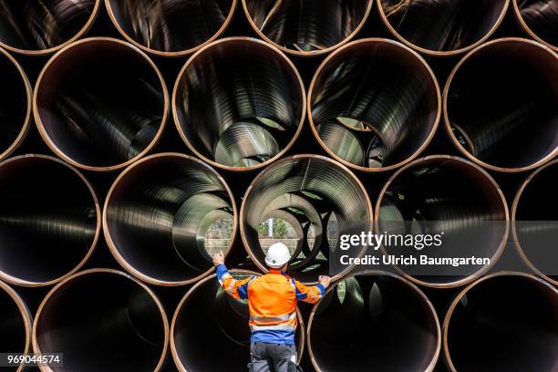 Large pipes for the Baltic Sea pipeline Nord Stream 2 on a storage area in the ferry port of Sassnitz/Neu Mukran. An employee of the responsible...