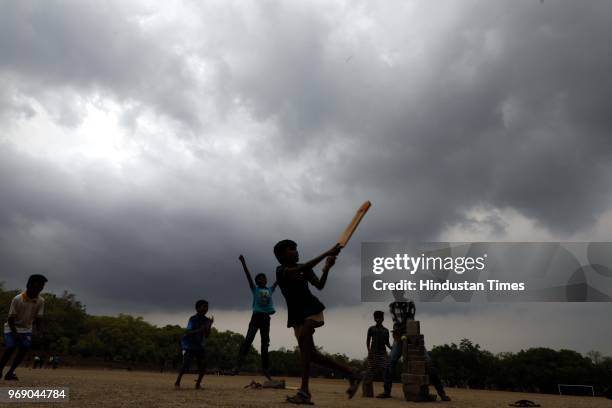 Boys playing cricket in cloudy weather at FC College Ground, on June 6, 2018 in Pune, India. An official at the India Meteorological Department said...