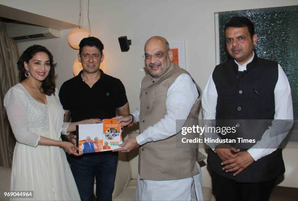 President Amit Shah along with Maharashtra CM Devendra Fadnavis meets Bollywood actor Madhuri Dixit with her husband Sriram Nene at her residence as...