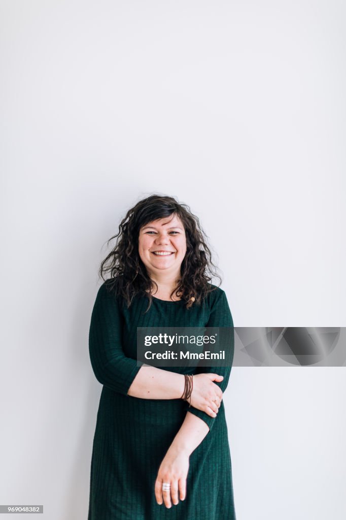 Body positive young female standing, smiling and looking at camera