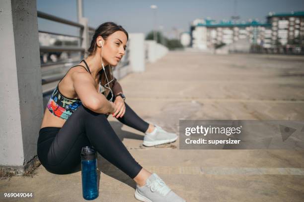 young woman stretching before exercise - high contrast athlete stock pictures, royalty-free photos & images