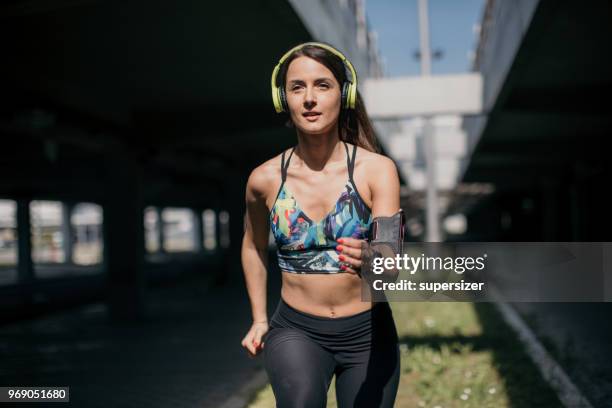 young female jogging outdoors - one young woman only stock pictures, royalty-free photos & images